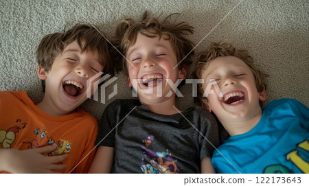Father joyfully embracing his sons at home, lying on the floor and sharing laughter. Generated image 122173643