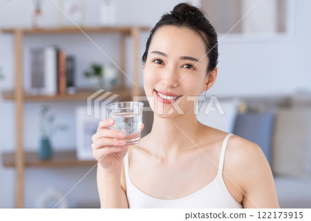 一個年輕的女人喝礦泉水 122173915