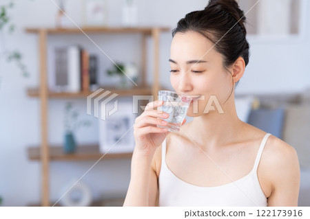 一個年輕的女人喝礦泉水 122173916