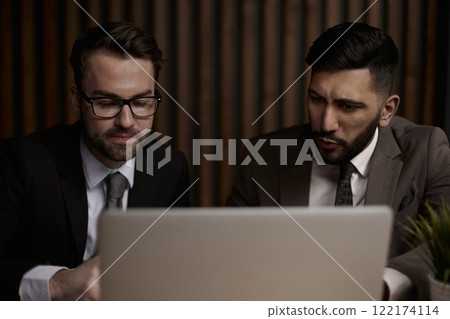 Two men discussing company growth, looking at rising graph on la Two men discussing company growth, looking at rising graph on la 122174114