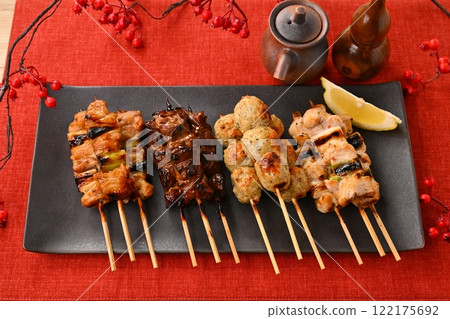長盤子上排列著烤雞肉串。加入醬汁、鹽、蔥、肉丸、肝臟和檸檬。 長盤子上排列著烤雞肉串。加入醬汁、鹽、蔥、肉丸、肝臟和檸檬。 122175692