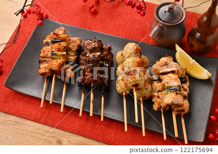 長盤子上排列著烤雞肉串。加入醬汁、鹽、蔥、肉丸、肝臟和檸檬。 122175694