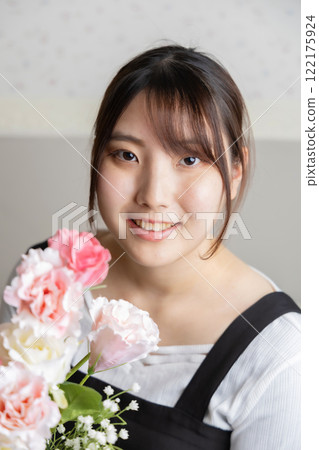 Young woman with flowers in bloom 122175924