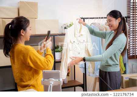 Two asian woman taking picture of clothes for online store. 122176734