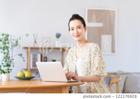 Young woman using a computer at home Young woman using a computer at home 122176928