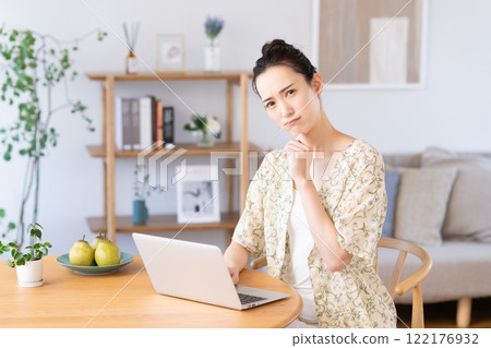Young woman using a computer at home Young woman using a computer at home 122176932