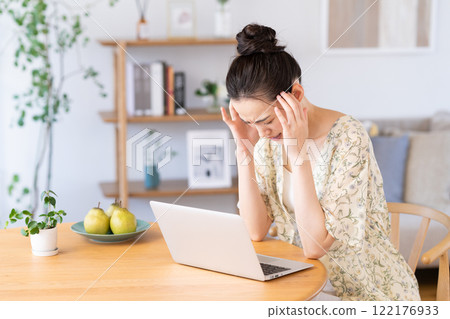Young woman using a computer at home Young woman using a computer at home 122176933