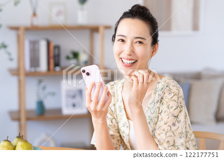 Young woman using a smartphone at home Young woman using a smartphone at home 122177751