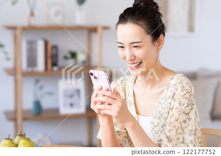 Young woman using a smartphone at home Young woman using a smartphone at home 122177752