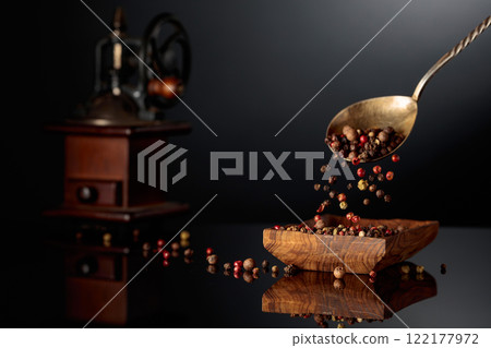 Black, red, white, and allspice peppercorns is poured in wooden dish. Black, red, white, and allspice peppercorns is poured in wooden dish. 122177972