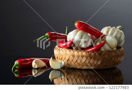 Garlic bulbs and red chili peppers on a black background. Garlic bulbs and red chili peppers on a black background. 122177983
