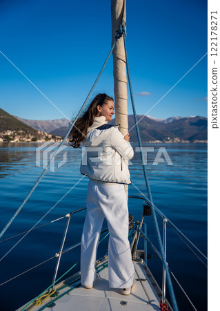 Portrait of young woman on bow of the yacht during sailing in the morning in winter time in Adriatic sea, yacht life and yachting concept Portrait of young woman on bow of the yacht during sailing in the morning in winter time in Adriatic sea, yacht life and yachting concept 122178271
