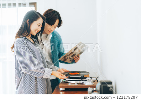 Young couple listening to records together 122179297