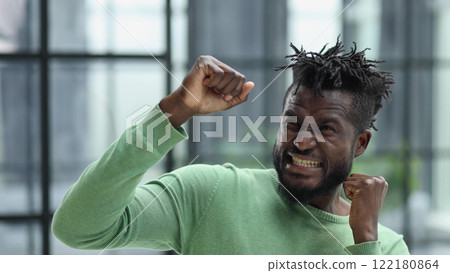 African man rejoices at the victory with his hands up African man rejoices at the victory with his hands up 122180864