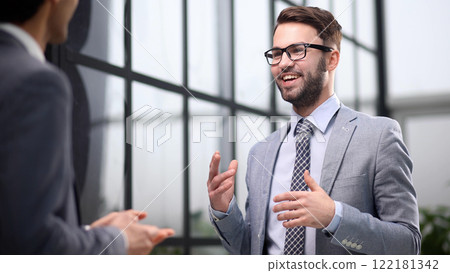 Diverse business people standing in coworking office talking 122181342