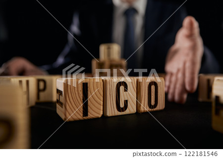 ICO symbol. Businessman hand turns wooden cubes ICO. ICO symbol. Businessman hand turns wooden cubes ICO. 122181546