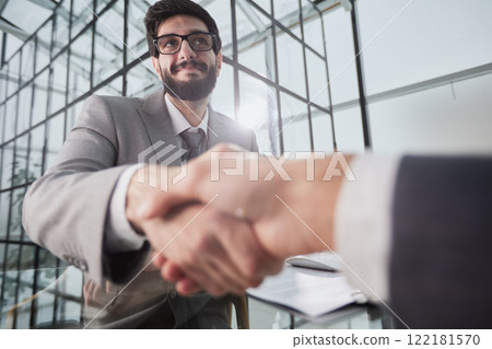 Handshake of two businessmen who enters into the contract to develop a new software to improve business service at a company. 122181570