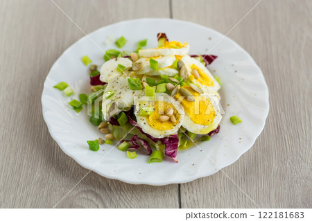 Homemade salad with greens in a plate on a wooden table 122181683