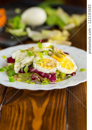 Appetizing egg dish in a plate on a wooden table Appetizing egg dish in a plate on a wooden table 122181685