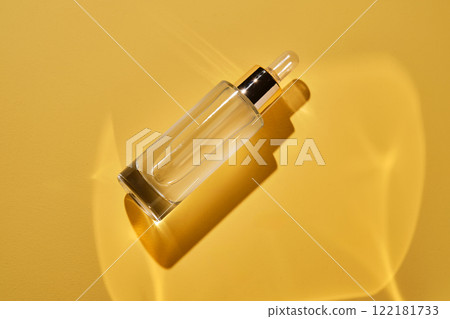 A bottle of serum on a yellow background. 122181733