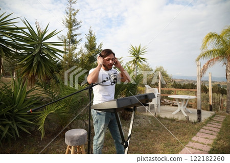 Musician Arranges His Keyboard For The Evening Performance In A Park 122182260