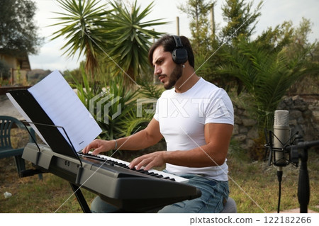 Singer Plays The Piano Outside In The Garden Near The Swimming Pool 122182266