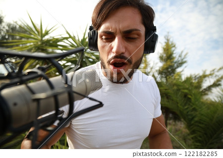 Singer Author Sets Up The Microphone And Sings Playing The Keyboard 122182285