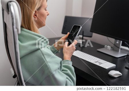 Woman holds a broken screen phone Woman holds a broken screen phone 122182591