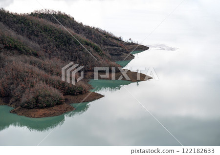 Reflections of mountain slope and brown soil in the Bovilla lake, Albania Reflections of mountain slope and brown soil in the Bovilla lake, Albania 122182633