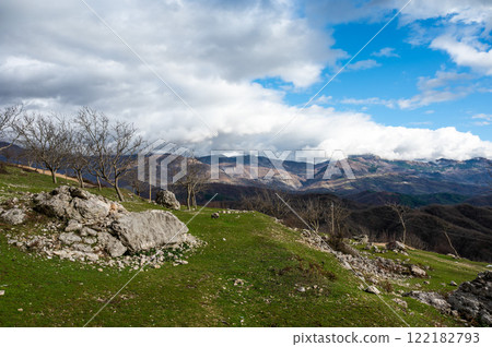 Fallen stone and rock formation with a mountain background at Gamti Mountain, Albania Fallen stone and rock formation with a mountain background at Gamti Mountain, Albania 122182793