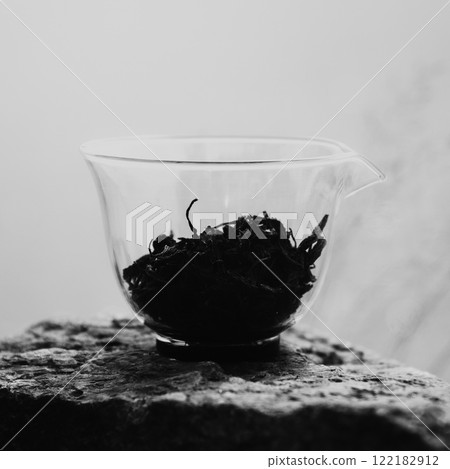 An Aesthetic Composition of Artistic Black and White Tea Leaves in a Glass Measuring Cup An Aesthetic Composition of Artistic Black and White Tea Leaves in a Glass Measuring Cup 122182912