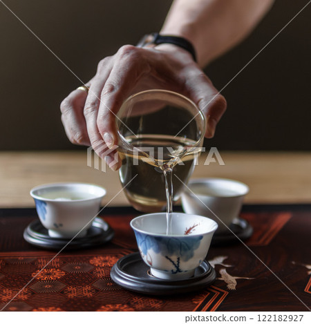 An Elegant and Graceful Tea Ceremony Pouring Traditional Tea into Exquisite Fine Cups An Elegant and Graceful Tea Ceremony Pouring Traditional Tea into Exquisite Fine Cups 122182927