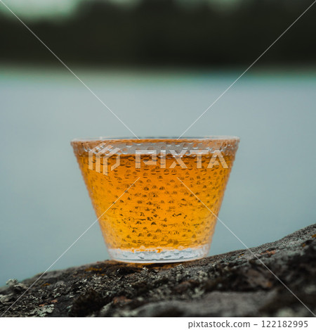 Enjoying a golden beverage displayed beautifully in a rustic and picturesque setting Enjoying a golden beverage displayed beautifully in a rustic and picturesque setting 122182995
