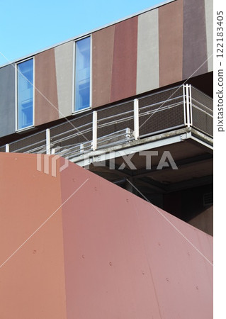 abstract fragment of an exterior view of modern architecture building in the city against a blue sky, wall of futuristic facade of urban development abstract fragment of an exterior view of modern architecture building in the city against a blue sky, wall of futuristic facade of urban development 122183405