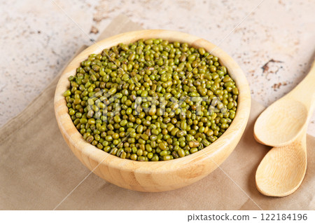 Mung beans in a bowl on beige table background, close up 122184196