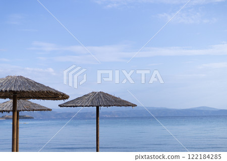 straw umbrellas on the background of the horizon line on the sea coast straw umbrellas on the background of the horizon line on the sea coast 122184285