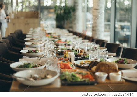 Long banquet served tables with snacks and cold dishes 122184414