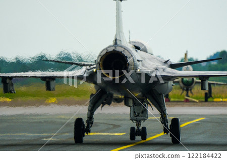 Swirling hot air behind the turbine exhaust of a working fighter jet, blurred photo 122184422