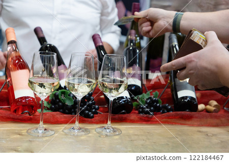 buyer's hand taking a bottle of wine from stand buyer's hand taking a bottle of wine from stand 122184467