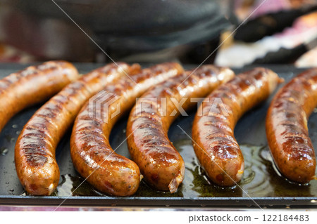 fresh juicy toasted German sausages lie on the grill, ready to eat. 122184483