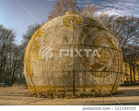 Large Decorative Christmas Ball with Intricate Patterns in a Park Setting 122184520
