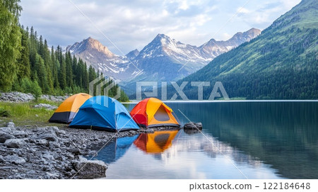 Colorful tents by a serene lake surrounded by majestic mountains in a tranquil camping setting 122184648