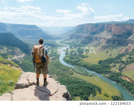 Hiker enjoying breathtaking view of expansive canyon and river under clear sky during daylight 122184653