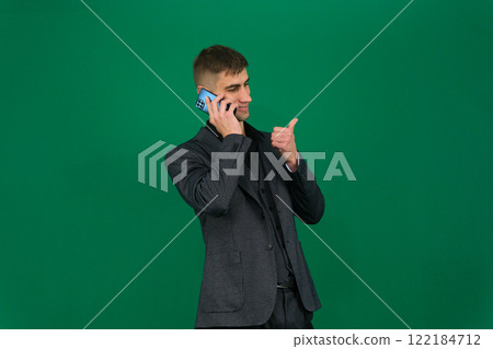 Positive man hold mobile smile and show thumb up confident face isolated Positive man hold mobile smile and show thumb up confident face isolated 122184712