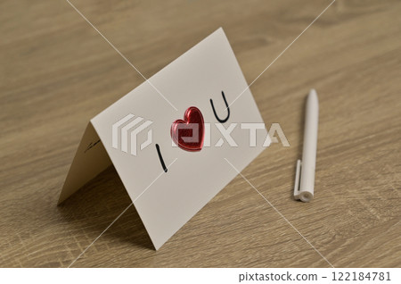 Valentine's Day greeting card romantic letter with red heart and pen on wooden table. Preparation to celebration 122184781
