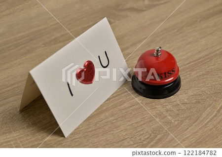 Valentine's Day greeting card romantic letter with heart and red bell on wooden table. Preparation to celebration 122184782