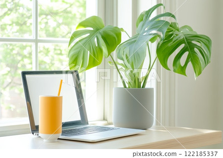 Modern table setup featuring a tablet stand and greenery, suitable for technology, productivity, or relaxed home aesthetics 122185337