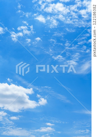 Stunning Light Blue Sky with Sparse White Clouds Perfect for Travel Brochures and Backgrounds 122186382