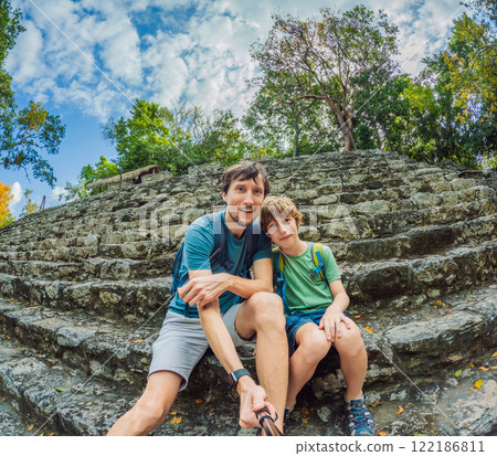 Father and son tourists exploring the ancient ruins of Coba, Mexico. Family bonding, cultural heritage, and adventure travel concept in the Yucatan Peninsula Father and son tourists exploring the ancient ruins of Coba, Mexico. Family bonding, cultural heritage, and adventure travel concept in the Yucatan Peninsula 122186811