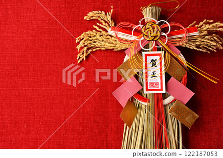 年初裝飾的新年裝飾，用稻穗裝飾，給人一種日本的感覺。以紅布為背景。 122187053